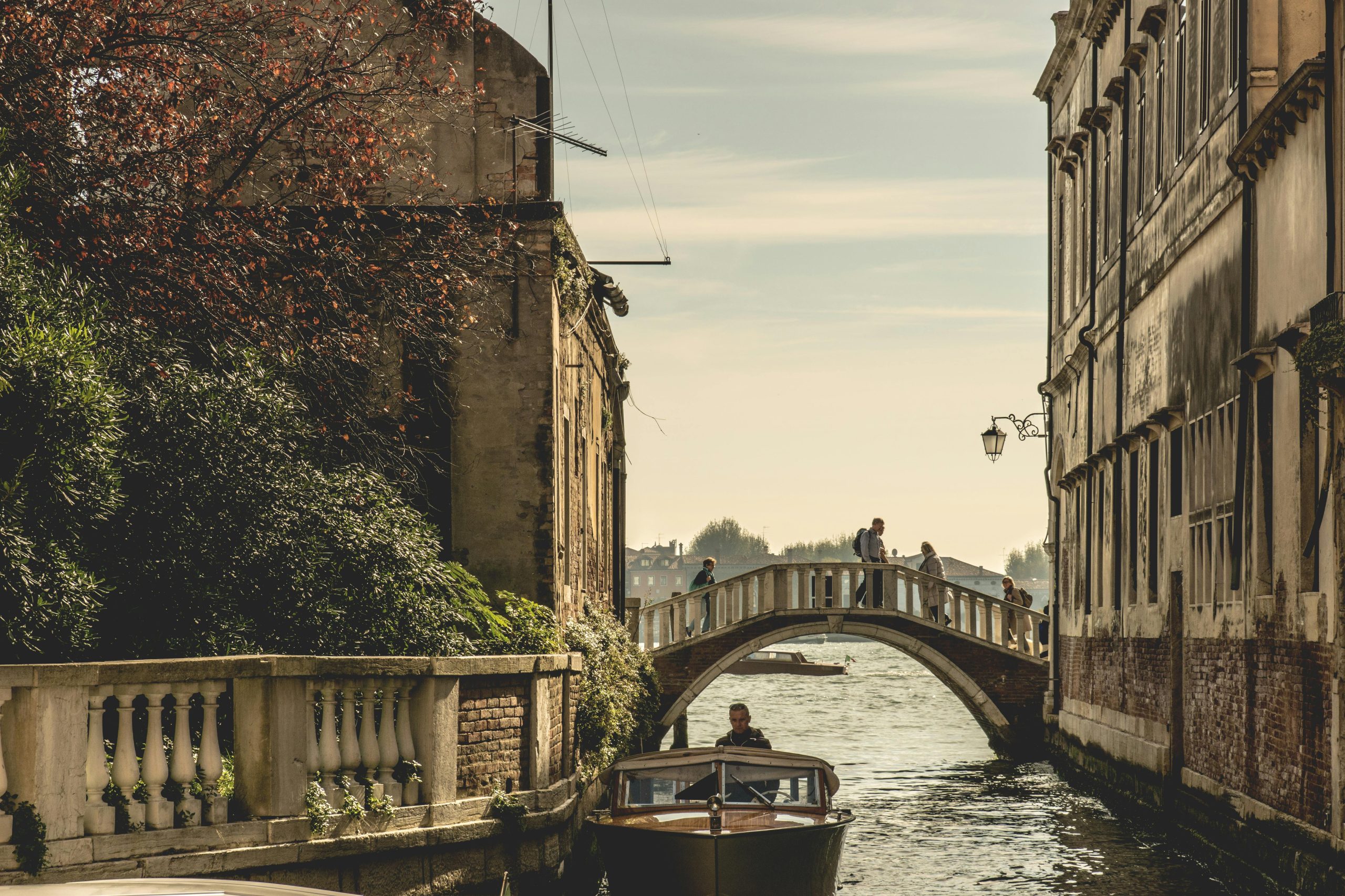 Captivating view of a Venetian canal with a bridge and boat, showcasing historic architecture.